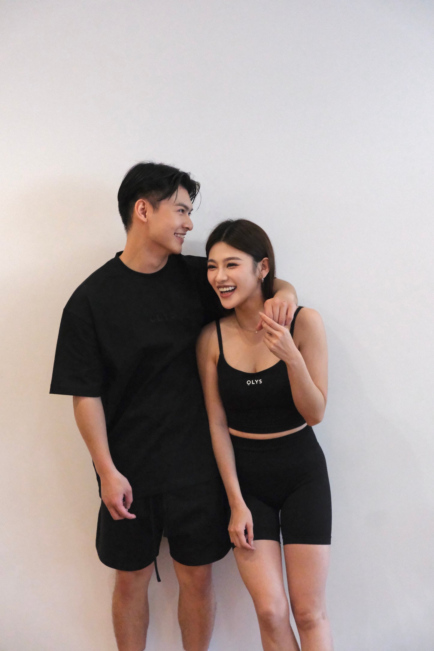 黑色 OLYS 刺繡 Logo 男裝 T 恤,搭配黑色棉短褲,極簡風格。OLYS 美背 U 型運動背心與高腰翹臀短褲,舒適彈性材質