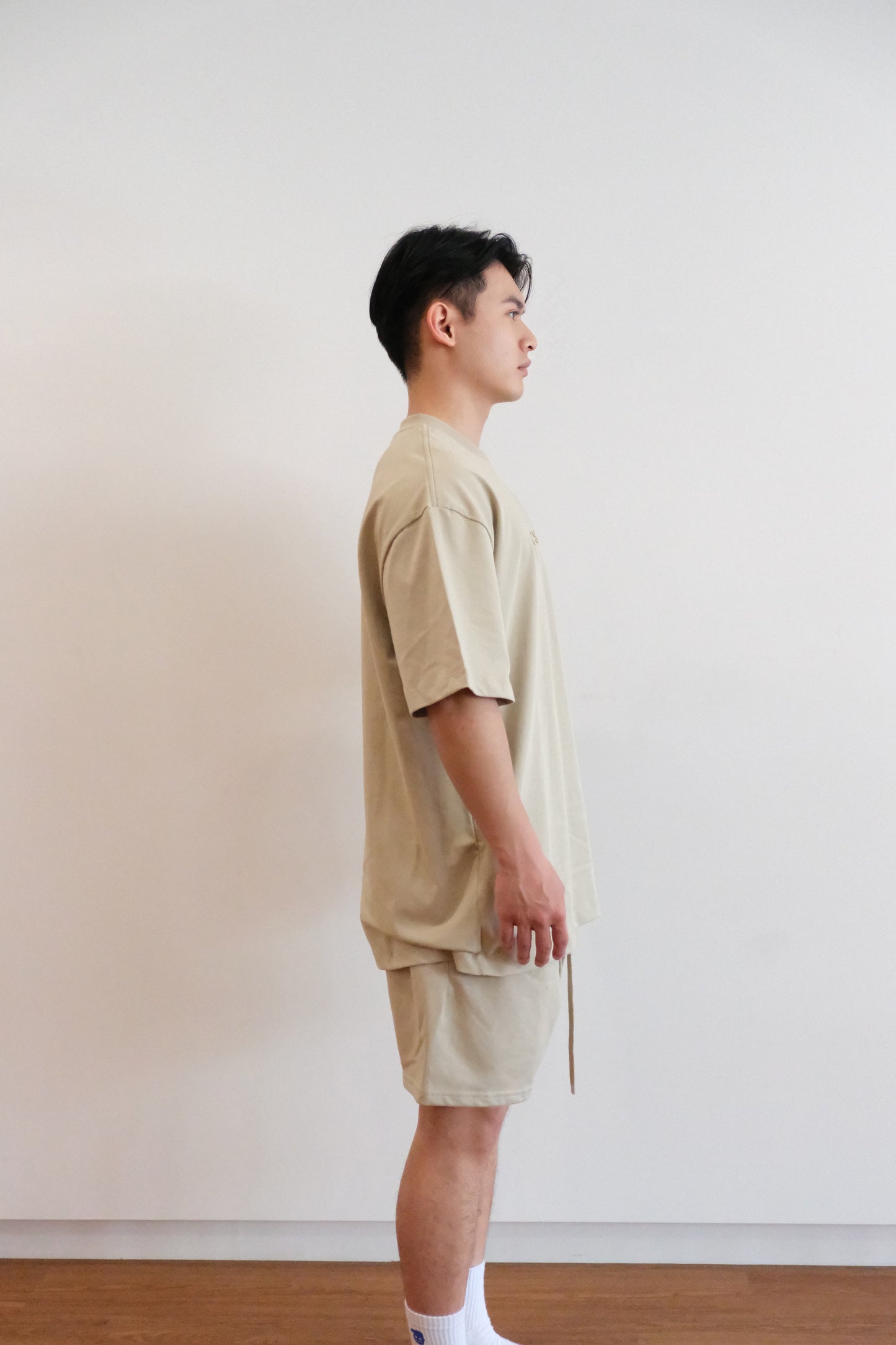 米色 OLYS 刺繡 Logo 寬鬆男裝 T 恤,搭配同色系棉質短褲,舒適休閒風格